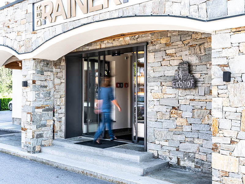 Eine Frau betritt ein Hotel durch eine Schiebetüre