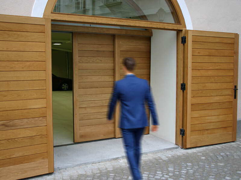 Ein Mann geht auf eine hölzerne Schiebetüre zu