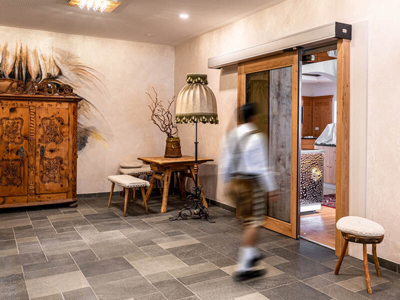 Ein Mann geht auf eine sich öffnende Schiebetüre zu