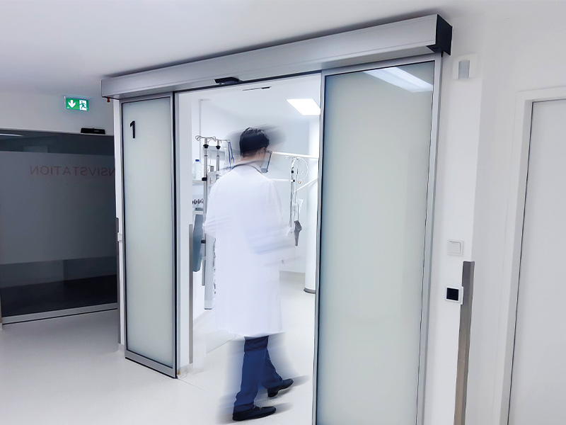 Arzt geht durch eine Schiebetüre in einen OP